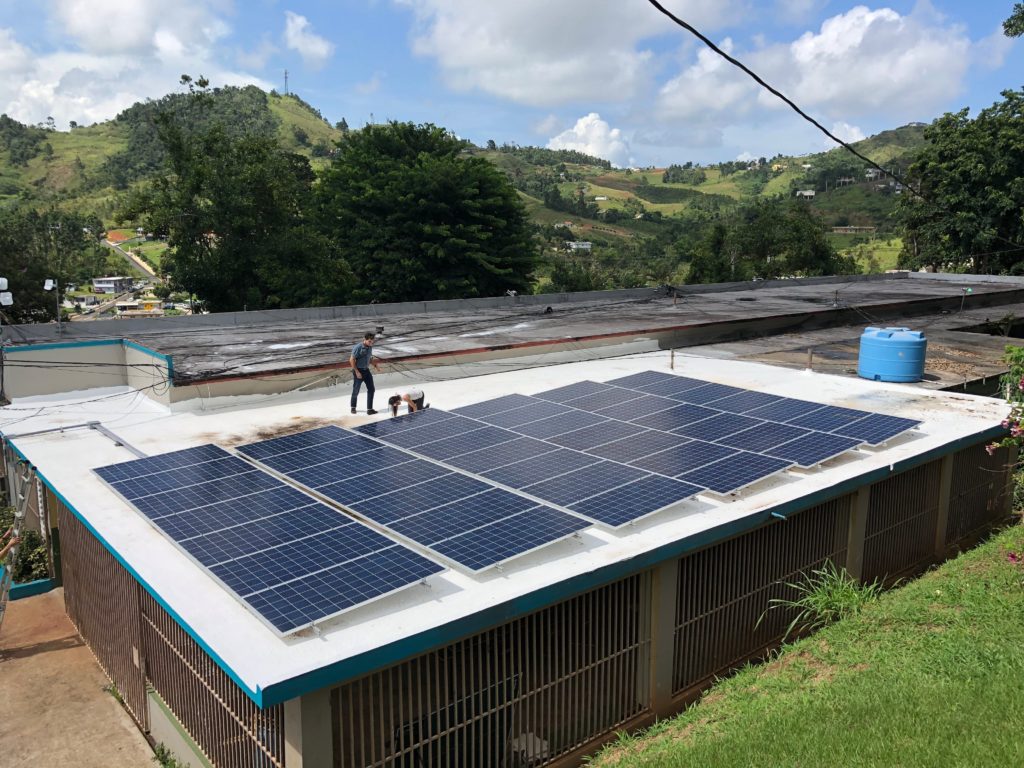 Megan Kerins and Michael Donatti of RMI inspecting the new solar panels on the school's roof 