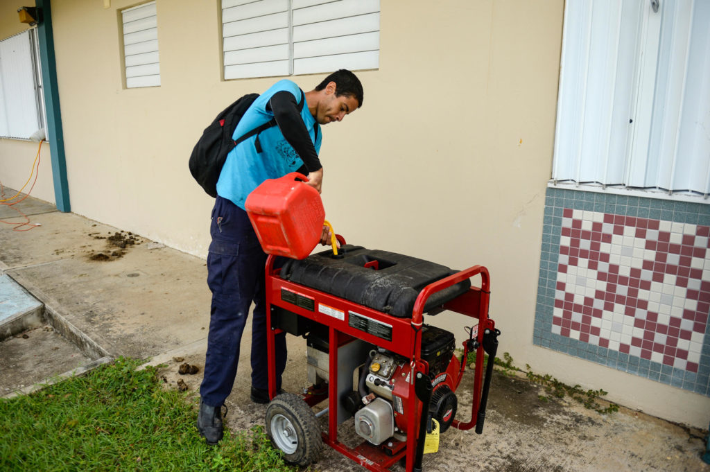 A man pouring fuel into a generator in Puerto Rico