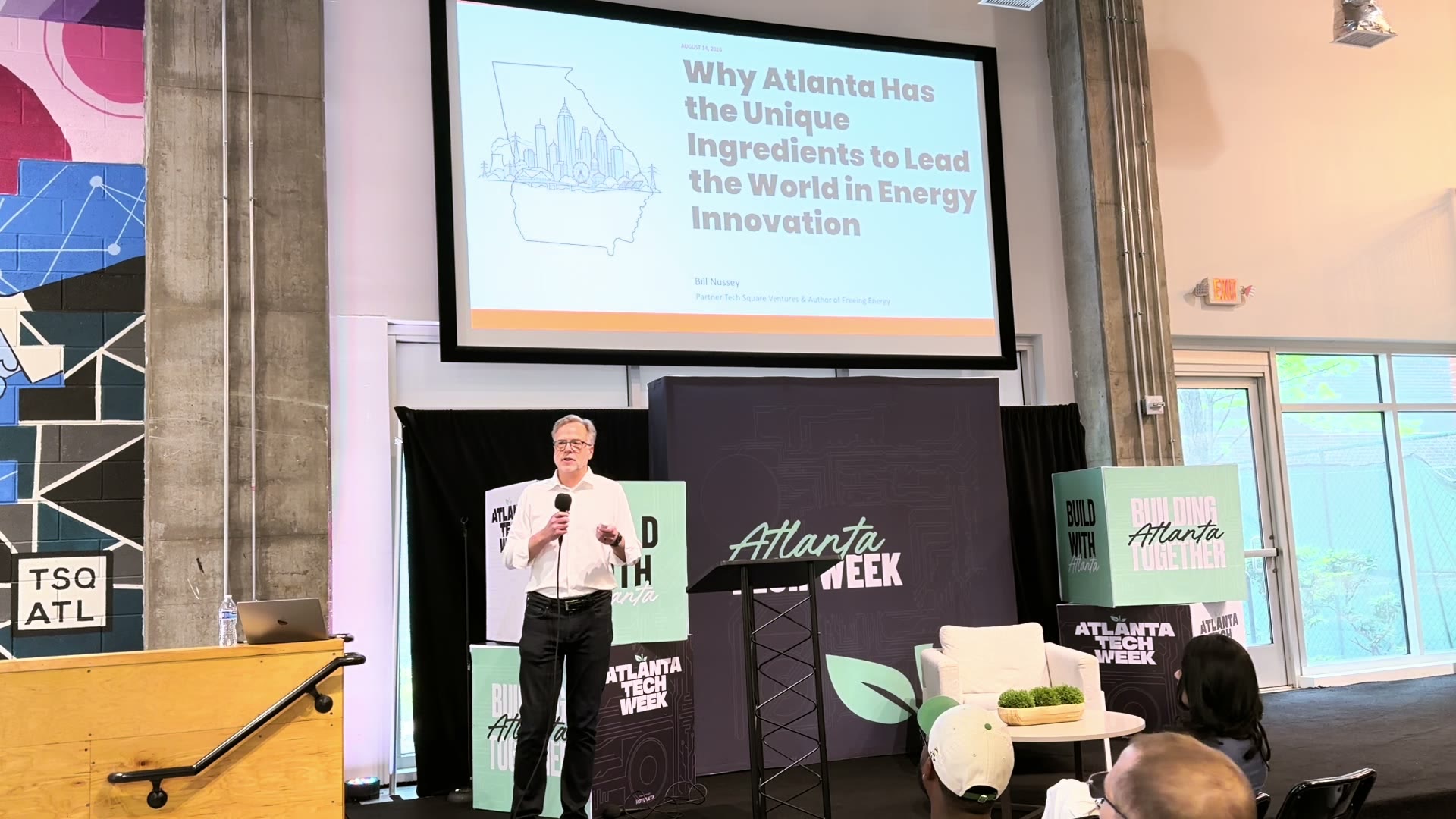 Bill Nussey on stage at Atlanta Tech Week beside his title slide, Why Atlanta Has the Unique Ingredients to Lead the World in Energy Innovation